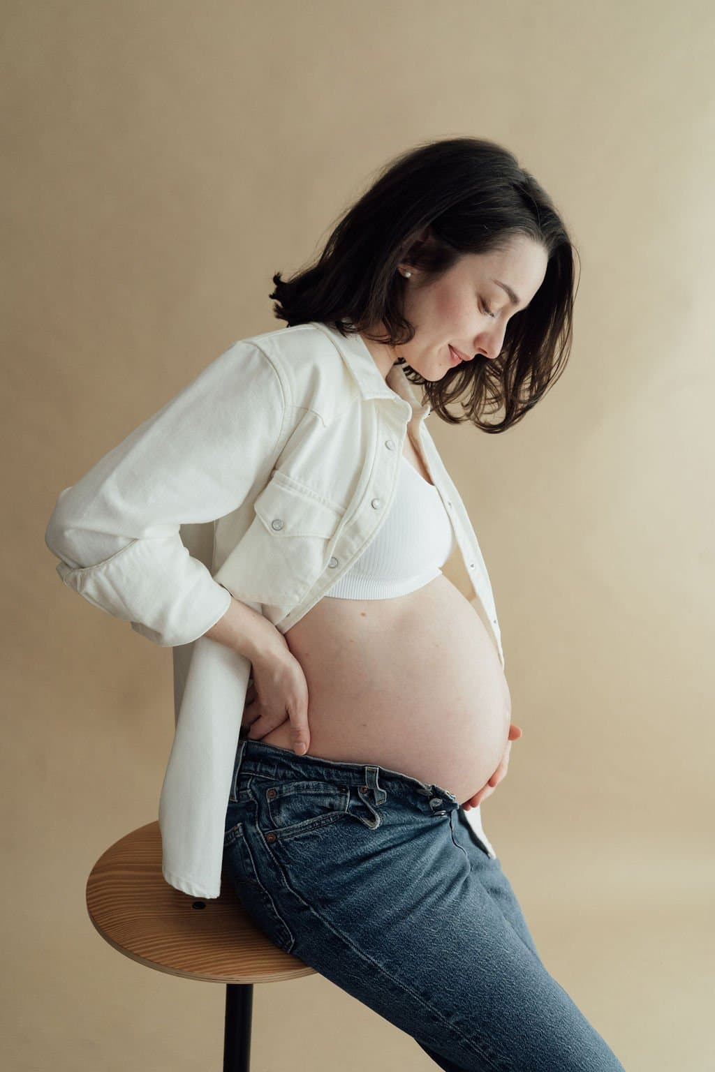 Séance photo grossesse en studio à Strasbourg, future maman en chemise blanche et jean