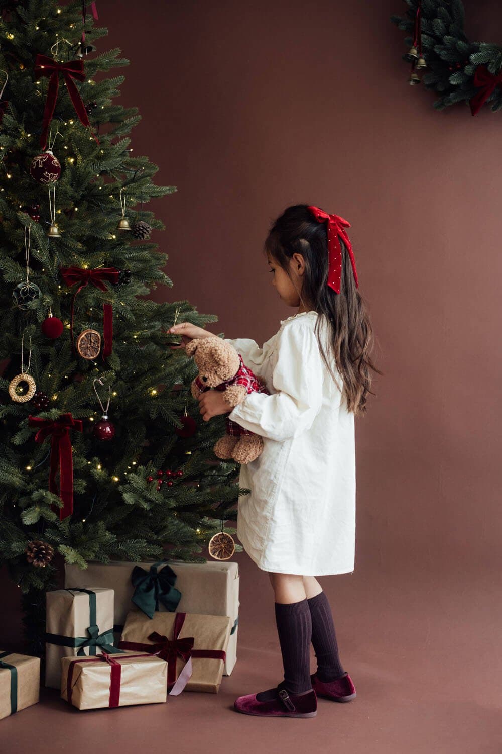 Fillette avec un ours en peluche près du sapin, studio photo à Strasbourg-Neudorf